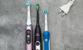 best electric toothbrush lead image: oral-b and phillips sonicare toothbrushes on grey background with charger